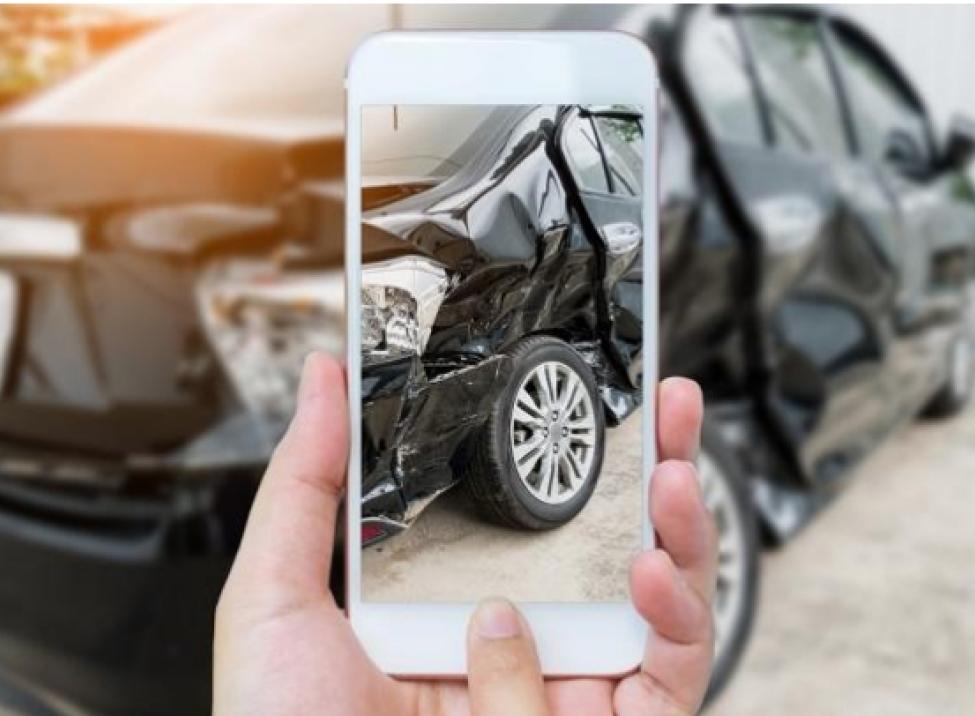 Teléfono celular tomando foto al vehículo dañado