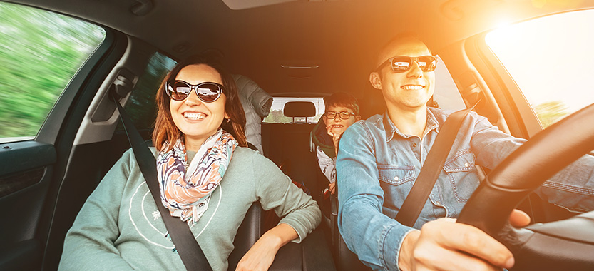 Foto de una familia feliz que viaja en un auto