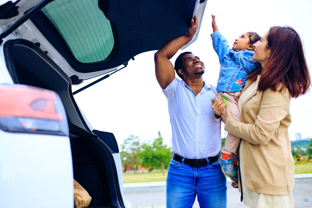 Happy family opening the back of their personal SUV