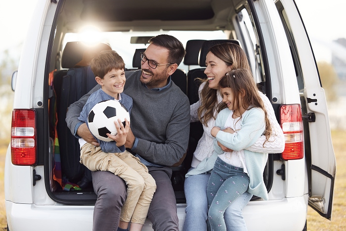 Familia de cuatro integrantes sentada en la parte trasera de una camioneta