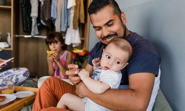 Father holding baby with his daughter