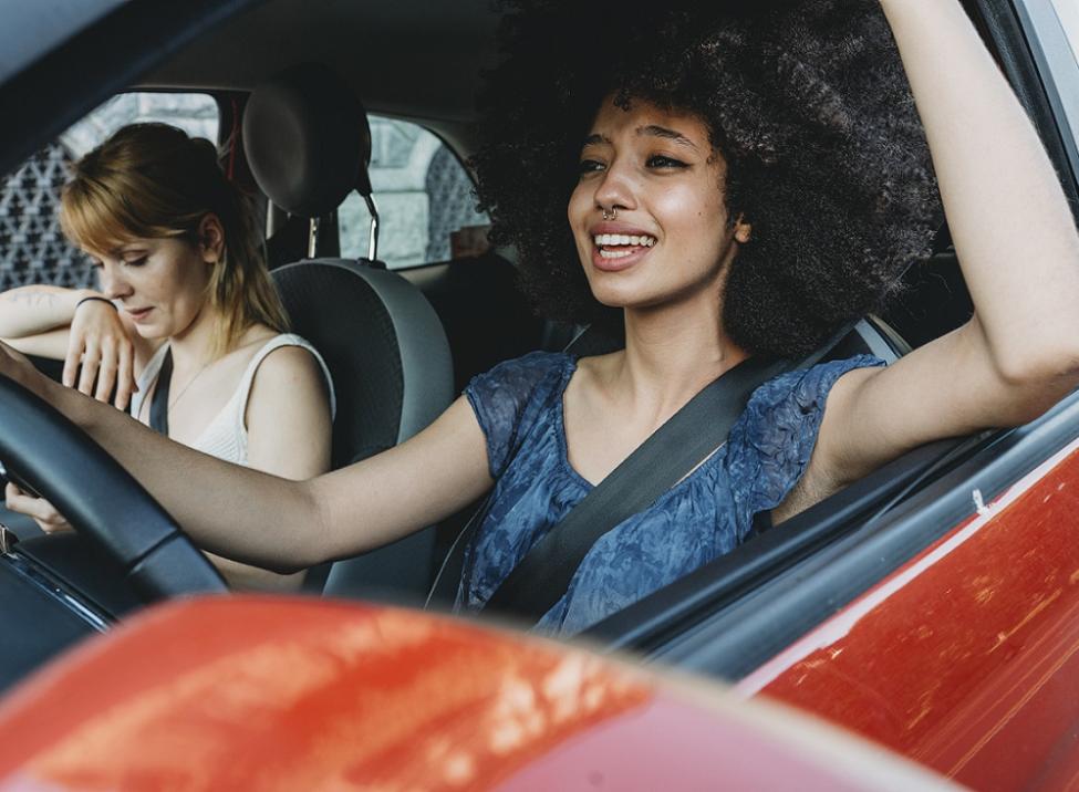 Two people driving in red car
