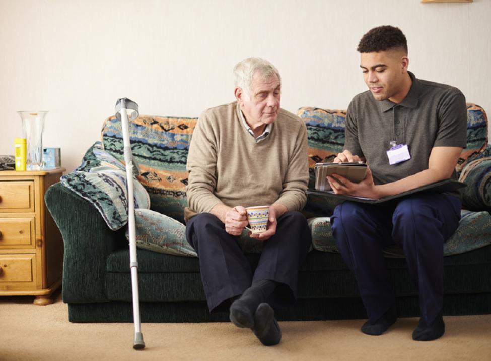 Paciente de edad avanzada recibiendo educación de un cuidador.
