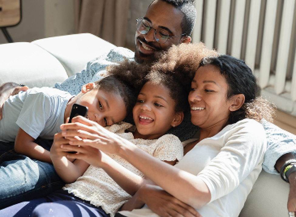 Family of four watching a mobile phone