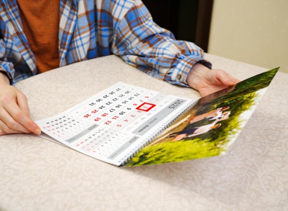 Photo of a person holding a calendar with a date circled