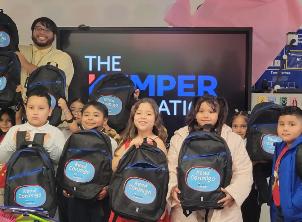 Los estudiantes muestran las mochilas de Read Conmigo proporcionadas por The Kemper Foundation en su salón de clases