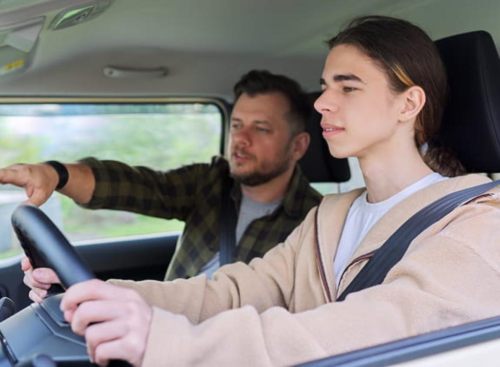 Father teaching his son to drive the family car
